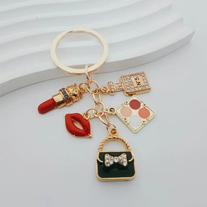 Porte-clés en émail élégant sur le thème des cosmétiques avec rouge à lèvres, fard à paupières et breloques pour sac à main