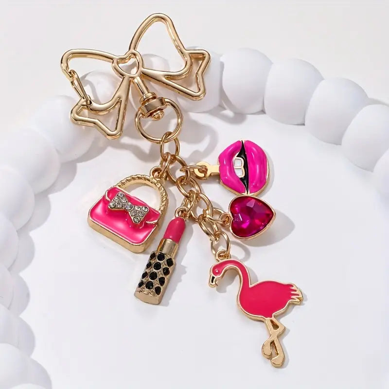 Llavero festivo de flamenco con labial rosa, corazón y lazo dorado: el regalo perfecto para el Día de la Mujer.